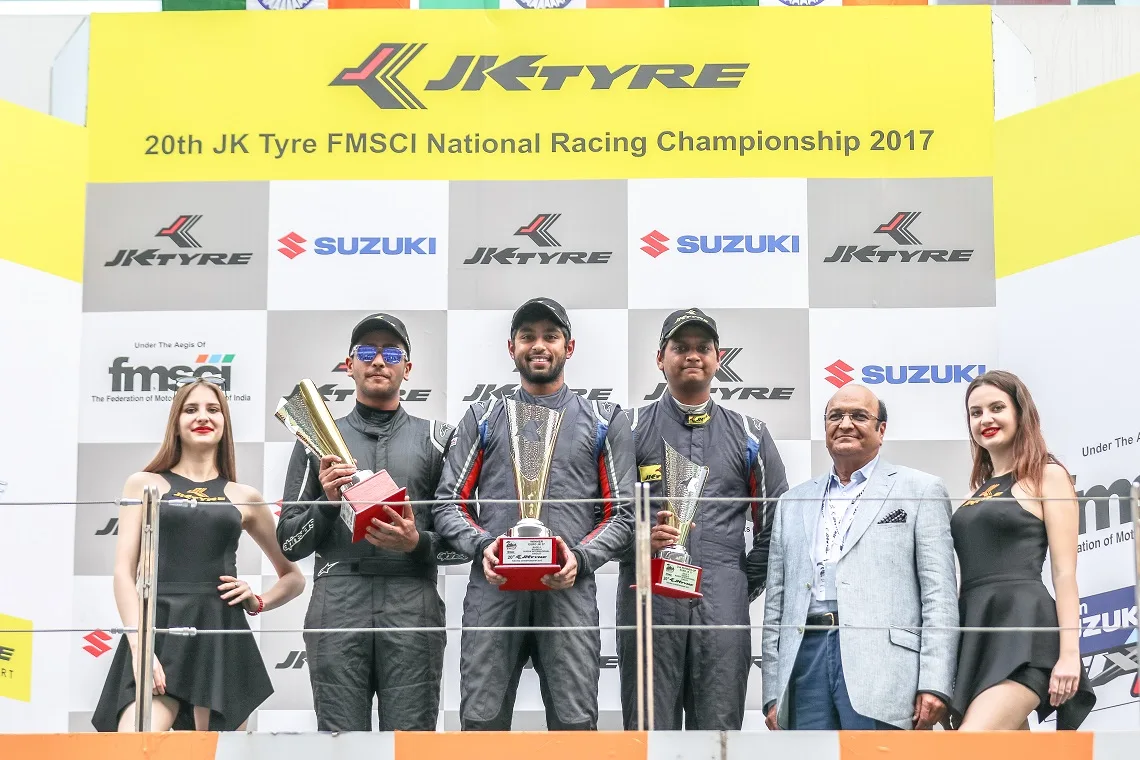 Champions hold their trophies on the podium of the 20th JK Tyre FMSCI National Racing Championship